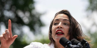 Alexandria Ocasio-Cortez speaking at an outdoor event.