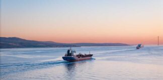 Cargo ship navigating through calm waters at sunset