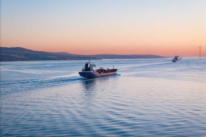 Cargo ship navigating through calm waters at sunset