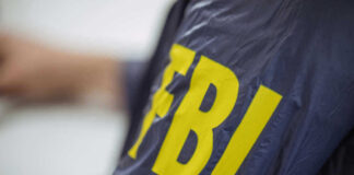 Person wearing FBI jacket, letters in yellow.