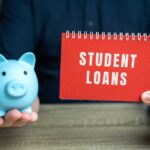 A blue piggy bank and a red notebook displaying 'STUDENT LOANS'
