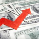 A red arrow indicating growth over scattered hundred dollar bills
