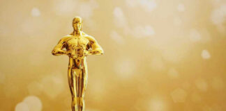 Golden Oscar trophy against a sparkling gold background.