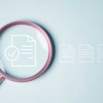 Magnifying glass focusing on a document with a checkmark