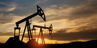 Oil pump jacks silhouetted against sunrise sky