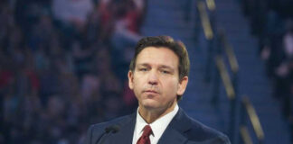 Man in suit speaking at a public event.