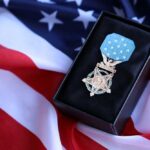 A military medal displayed on a black box with an American flag background