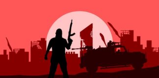 Silhouette of a soldier with a weapon against a red sunset and a military vehicle