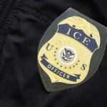 Close-up of an ICE officer badge on a black jacket
