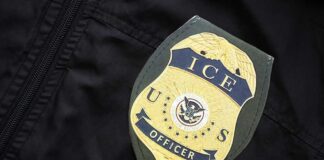 Close-up of an ICE officer badge on a black jacket