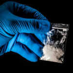Drug Dealer Who Killed TV Star Gets HAMMERED Hand in glove holding bag of white powder.