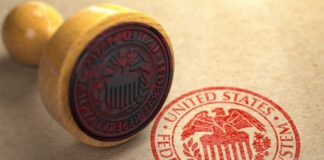 A wooden stamp with the Federal Reserve seal on a brown paper background