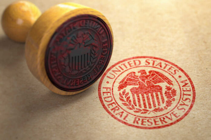 shutterstock_1487540675.jpg A wooden stamp with the Federal Reserve seal on a brown paper background