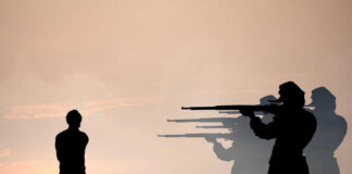 Silhouette of soldiers firing squadding a person