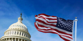 U.S. Capitol building with American flag waving.