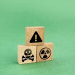 Wooden blocks displaying hazard symbols including a skull, radiation, and an exclamation mark