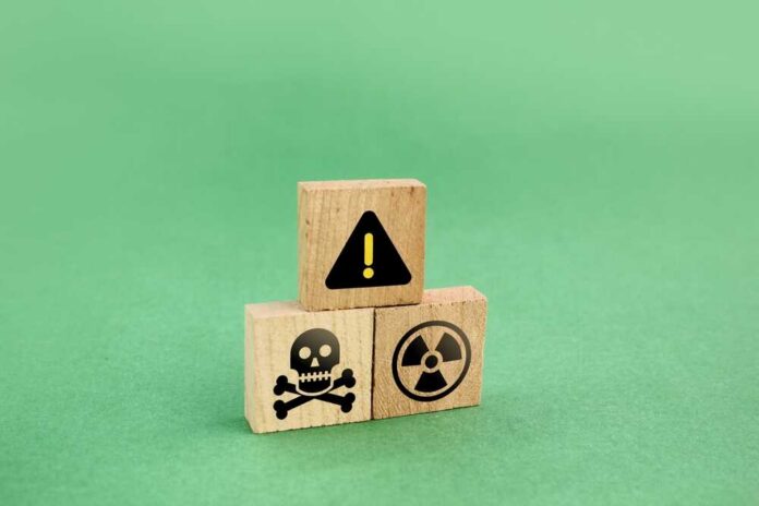 Wooden blocks displaying hazard symbols including a skull, radiation, and an exclamation mark