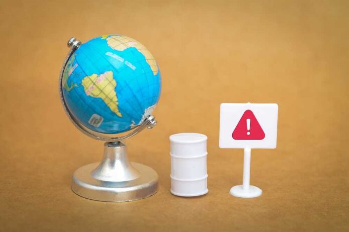 shutterstock_2735579791.jpg A miniature globe next to a warning sign and a barrel