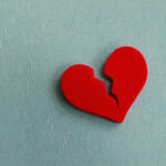 Broken red heart on a blue background.