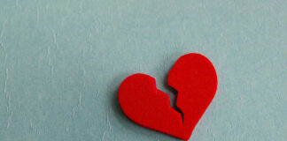 Broken red heart on a blue background.