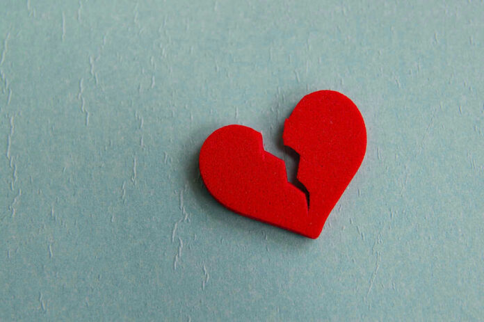 Broken red heart on a blue background.