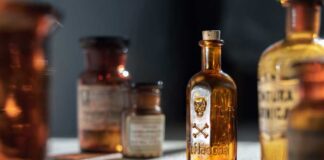 A collection of vintage glass bottles with labels on a wooden surface