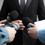 BUSTED: Reporter’s Fake Trump Call Journalists holding microphones and a notepad during a press conference