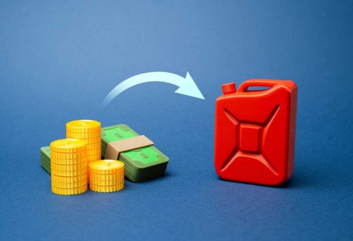 A stack of coins and bills next to a red fuel can