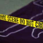 Yellow crime scene tape marking off an area with a chalk outline