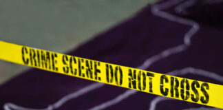 Yellow crime scene tape marking off an area with a chalk outline