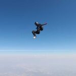 Skydiver in freefall against a clear blue sky