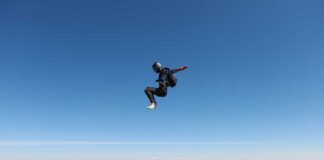 Skydiver in freefall against a clear blue sky