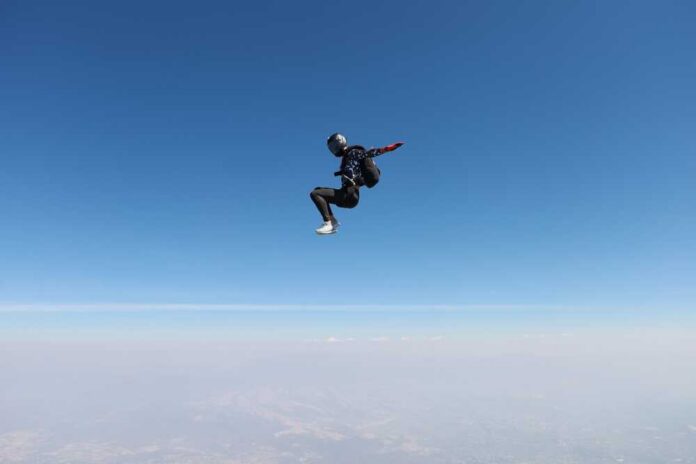 Skydiver in freefall against a clear blue sky