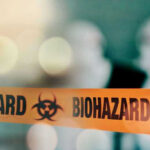 Biohazard tape with blurred figures in background.